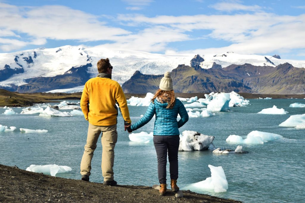 Couple holding hands overlooking Jokulsarlon lagoon, Iceland
