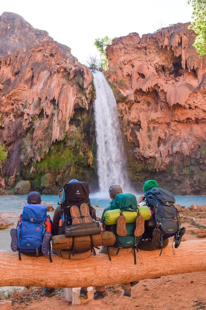 Family with backpacks on log at Havasu Falls, Havasuapai, Arizona