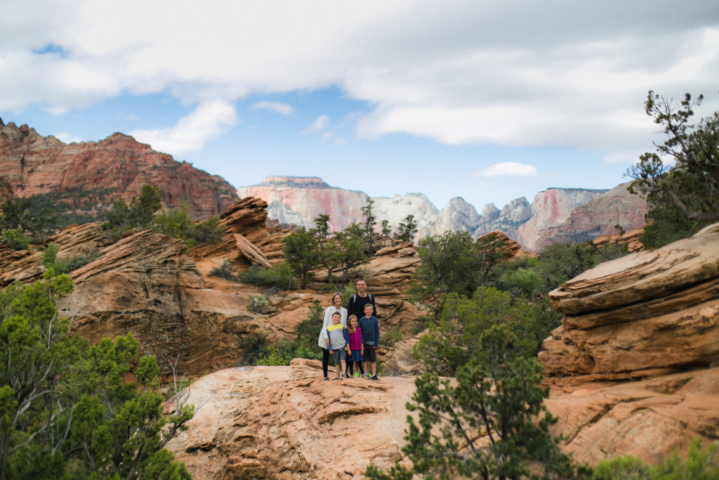 Family standing on rock at Canyon Overlook in Zion National Park, Utah