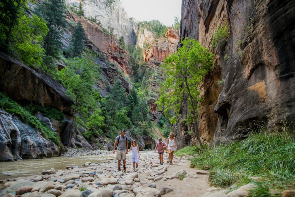 Family hiking through the Narrows in Zion National Park, Utah
