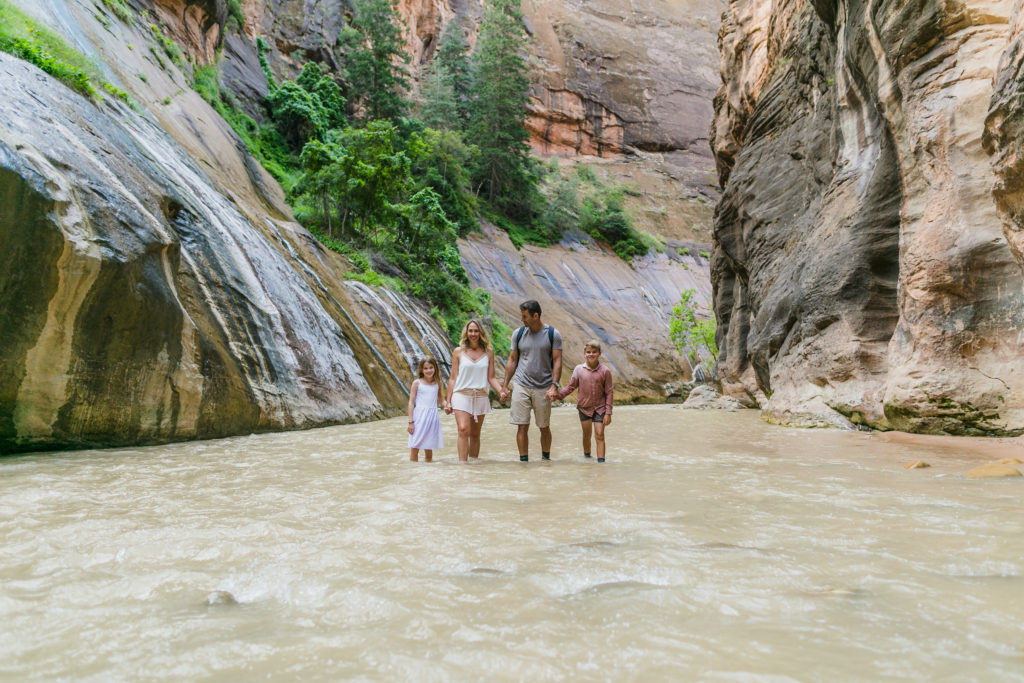 Family hiking through the Narrows in Zion National Park, Utah