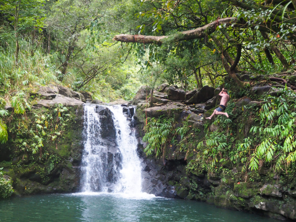 Man swinging off rope at Waikamoi Falls, Road to Hana, Maui