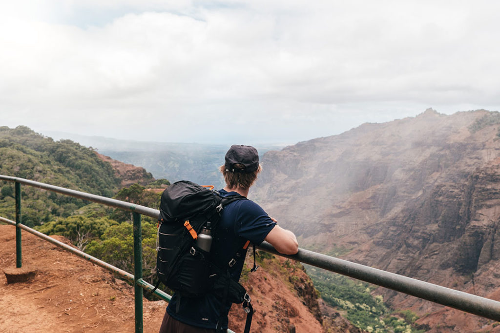 Man enjoying the view of Waimea Canyon on the trail to Waipo'o Falls, Kauai, Hawaii