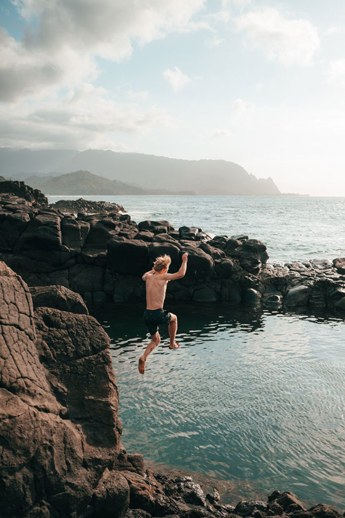 Man jumping into Queens Bath, Kauai, Hawaii