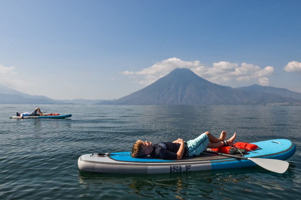Kids laying on paddleboards on Lake Atitlan, Guatemala