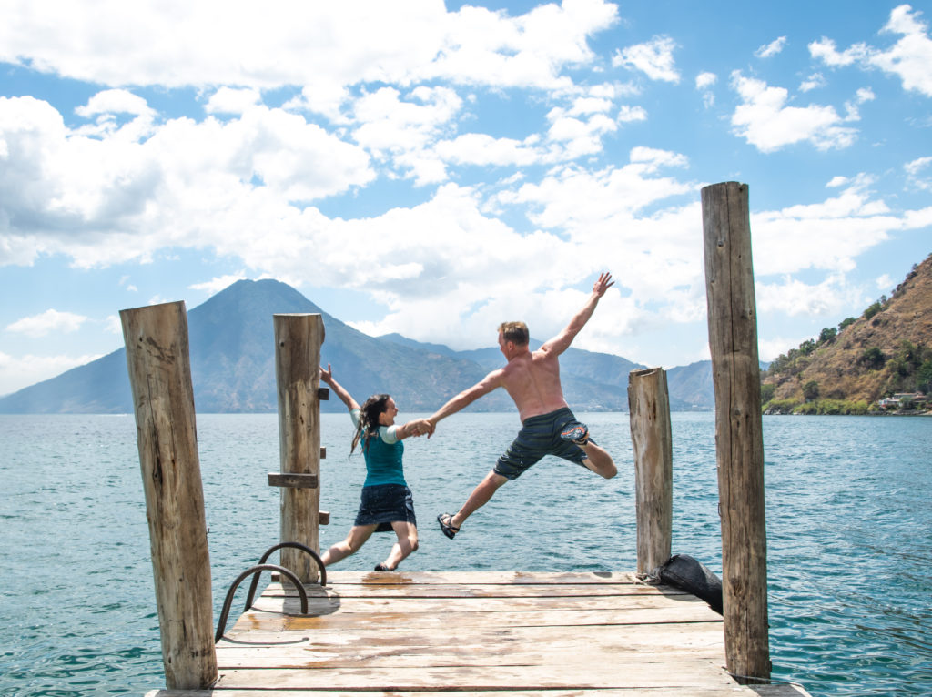 Couple jumping off dock on Lake Atitlan, Guatemala