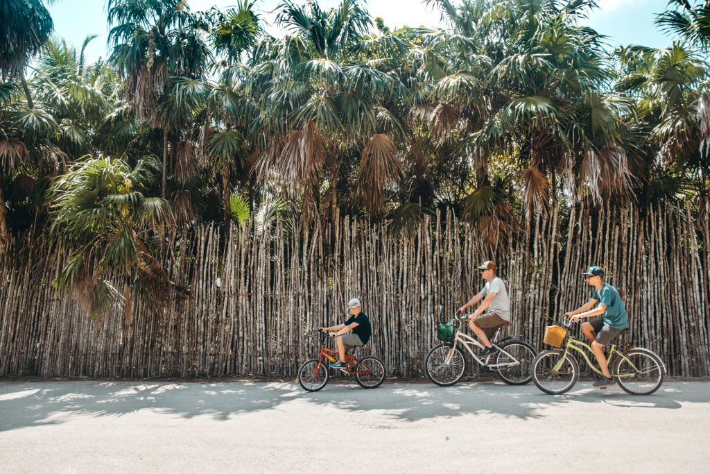 Family riding bikes in Tulum, Mexico
