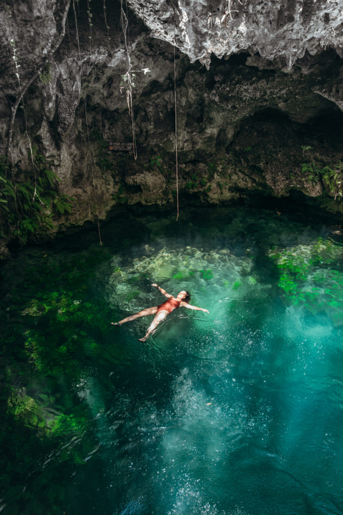 Woman floating in a cenote, Tulum, Mexico