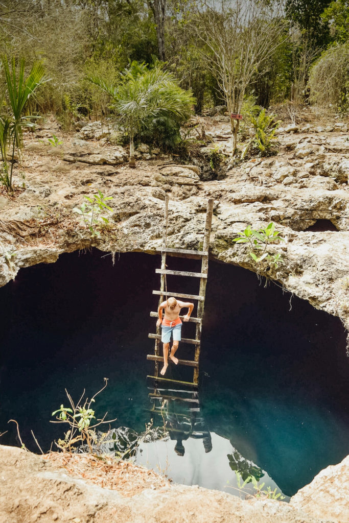 Kid climbing down ladder into Calaveras cenote, Mexico