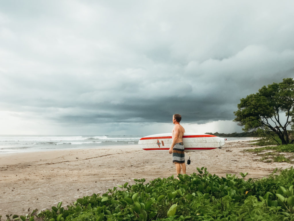 Surfer watching waves at Playa Guiones, Costa Rica