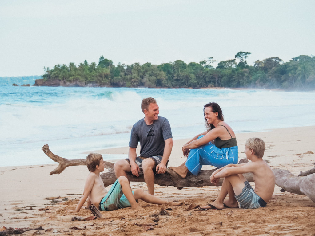 Family sitting on beach at Bluff Beach, Bocas del Toro, Panama