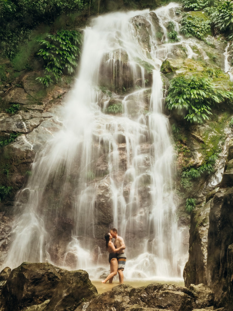 Couple kissing under falls of Marinka waterfall, Minca, Colombia