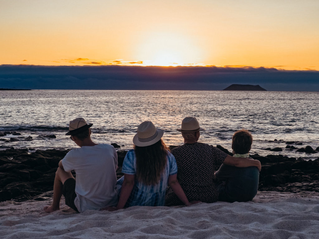 Family watching sunset on the Galapagos Islands, Ecuador